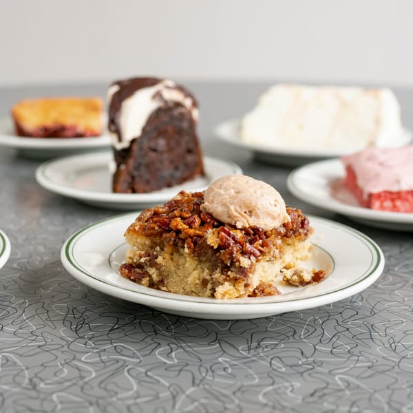 Various dessert slices, including pecan pie, chocolate cake, and strawberry cake, on white plates.